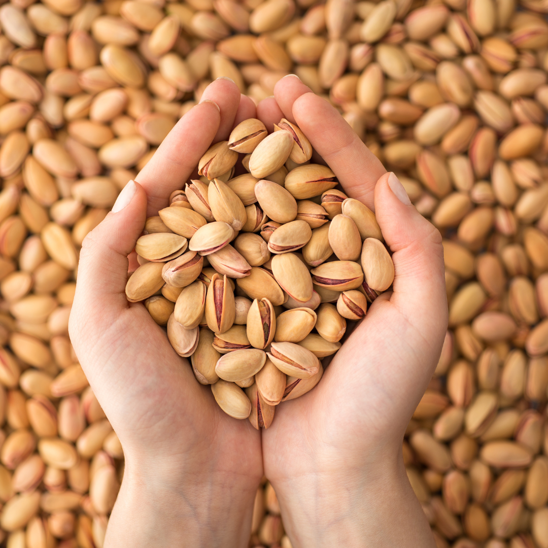 Close-up view of fresh Sabut Pista with vibrant green kernels.