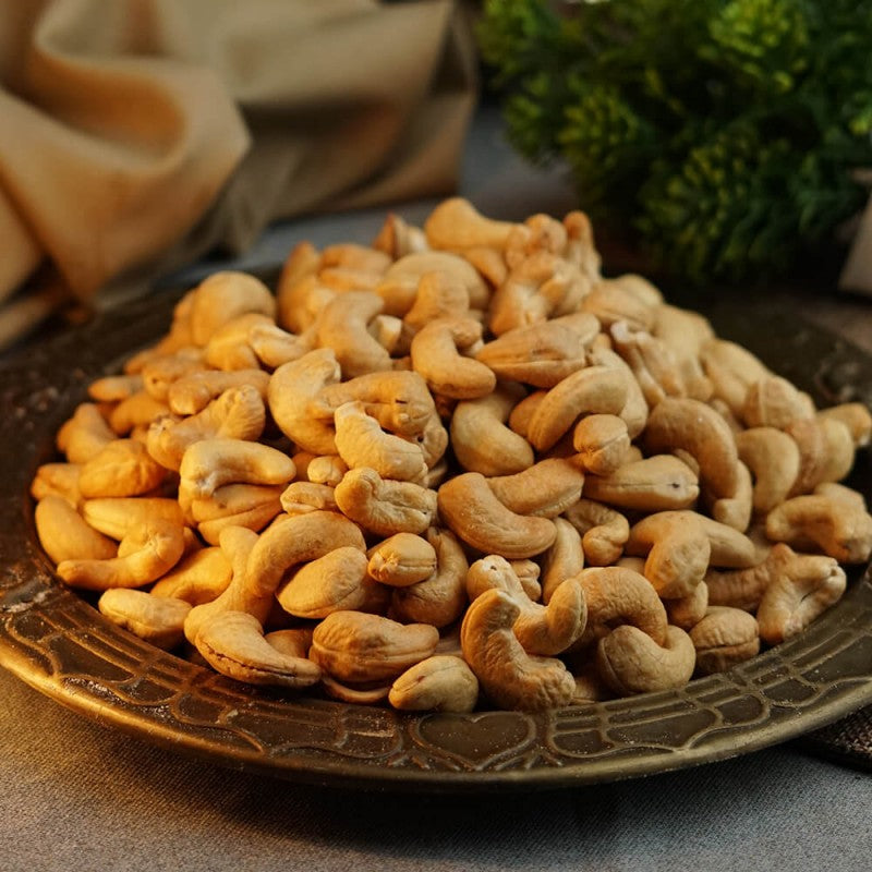 Close-up of roasted cashew nuts on a wooden surface.